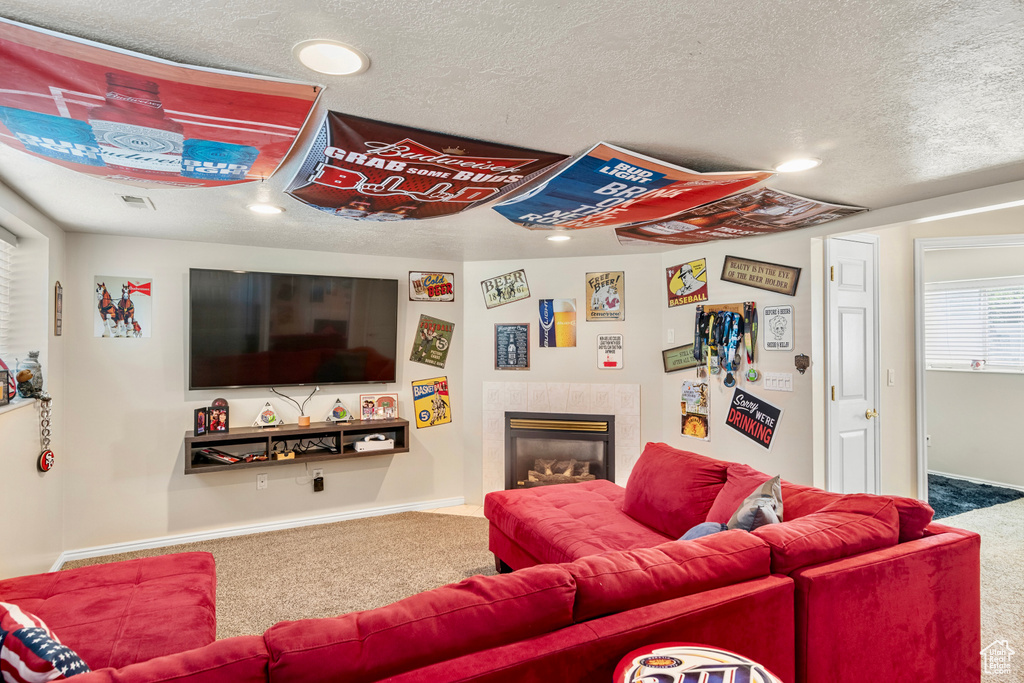 Carpeted living room with a fireplace and a textured ceiling