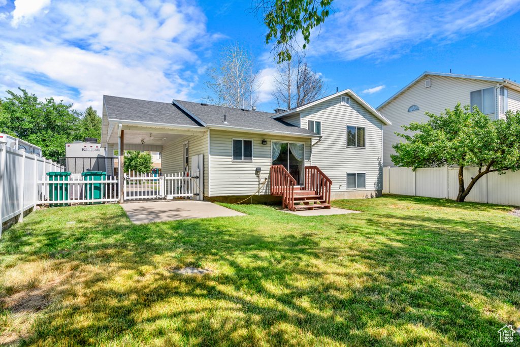 Back of house with a patio area and a lawn