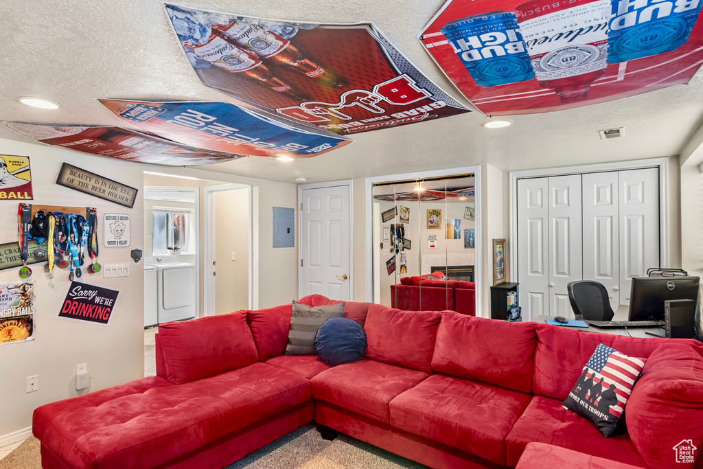 Living room with washer / clothes dryer, a textured ceiling, and electric panel