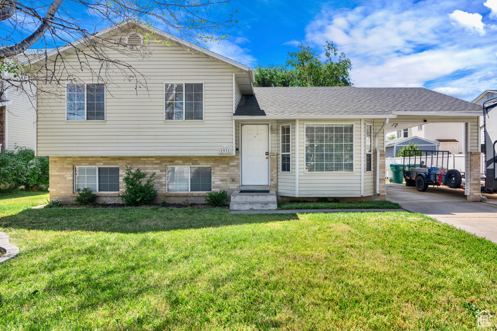 Split level home with a carport and a front yard