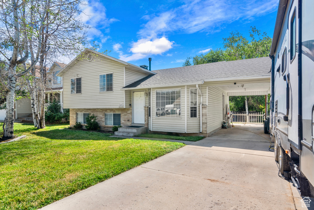 Split level home with a carport and a front lawn