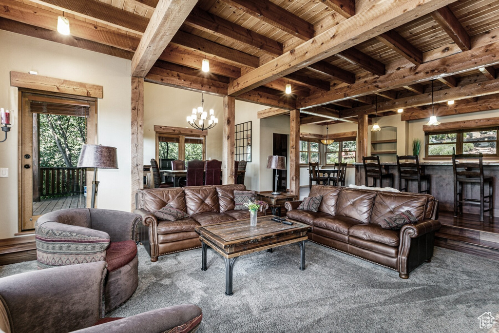 Living room with wood ceiling, beamed ceiling, an inviting chandelier, and hardwood / wood-style floors