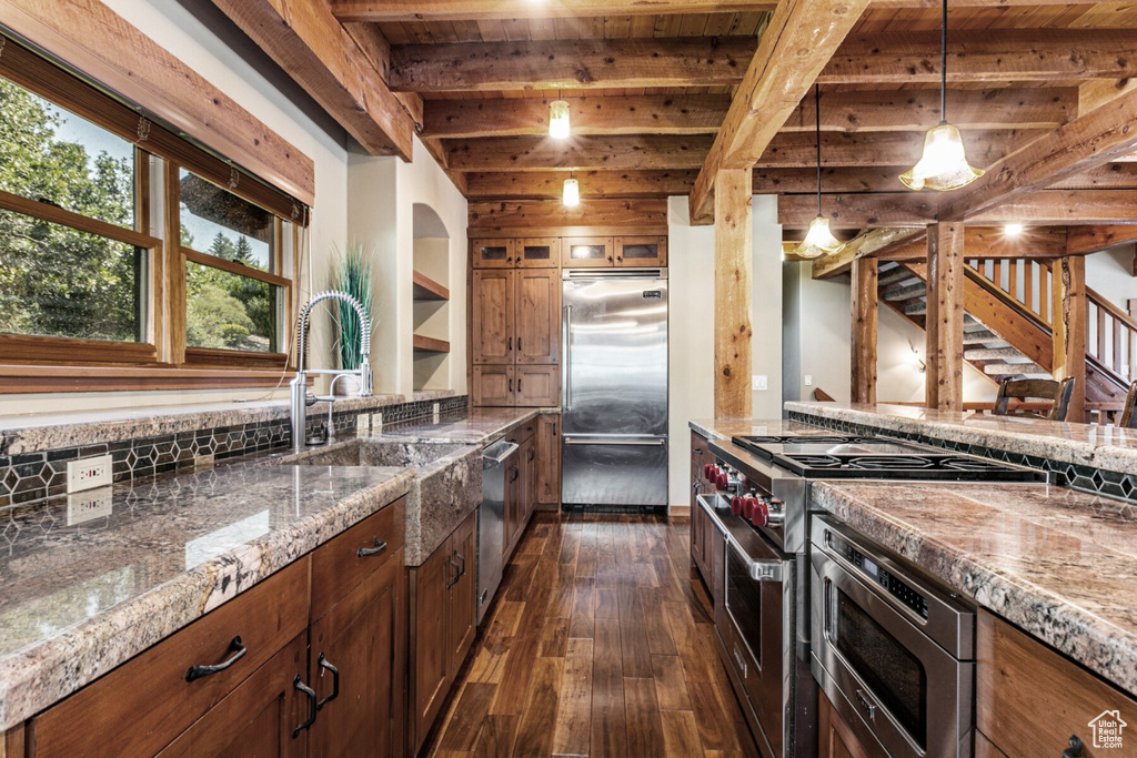 Kitchen with premium appliances, hanging light fixtures, beamed ceiling, dark hardwood / wood-style floors, and wood ceiling