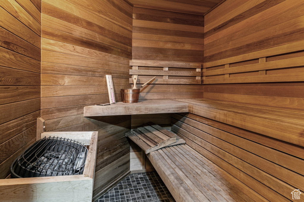 View of sauna / steam room with tile patterned flooring and wood walls