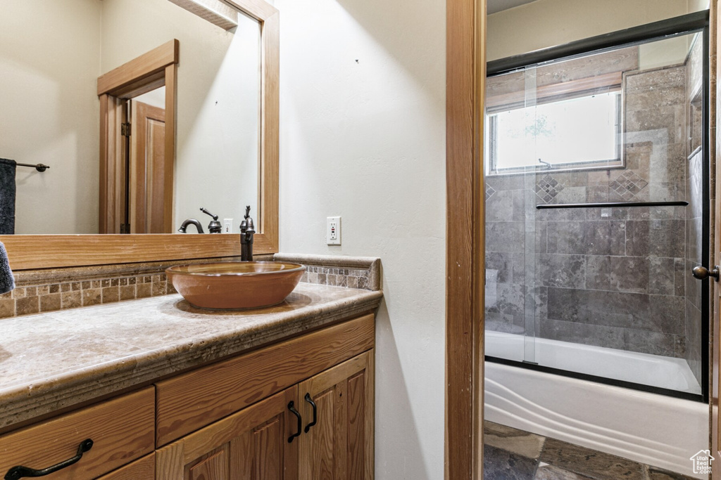 Bathroom with vanity and enclosed tub / shower combo