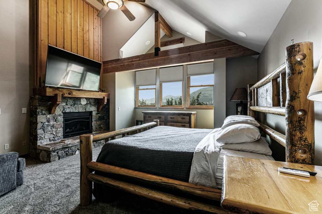 Bedroom featuring a stone fireplace, carpet flooring, high vaulted ceiling, and ceiling fan