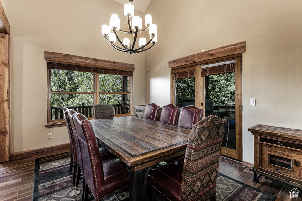 Dining space featuring a notable chandelier, high vaulted ceiling, and dark hardwood / wood-style floors