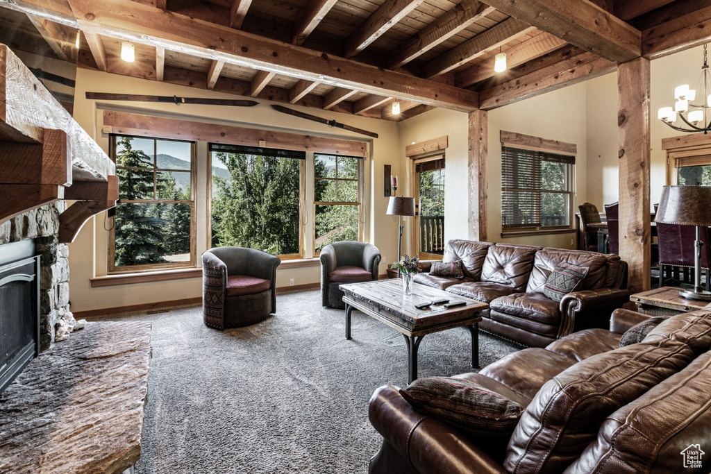 Living room featuring a notable chandelier, a fireplace, wooden ceiling, carpet floors, and lofted ceiling with beams