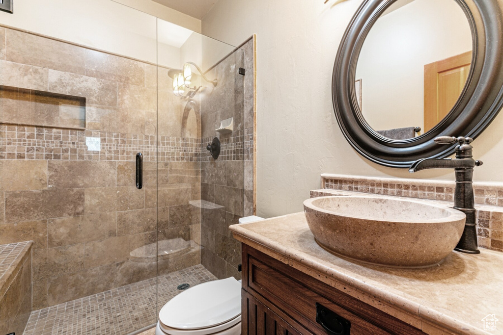 Bathroom featuring vanity, an enclosed shower, and toilet