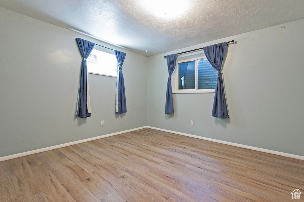 Spare room with a textured ceiling and hardwood / wood-style flooring