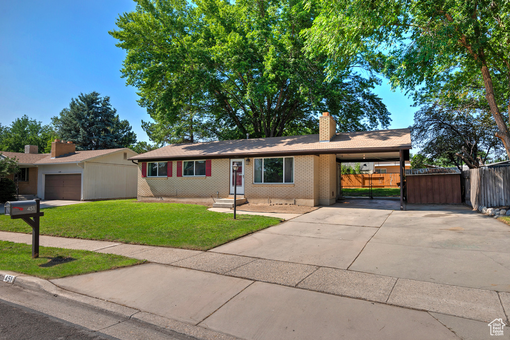 Ranch-style home featuring a garage and a front yard