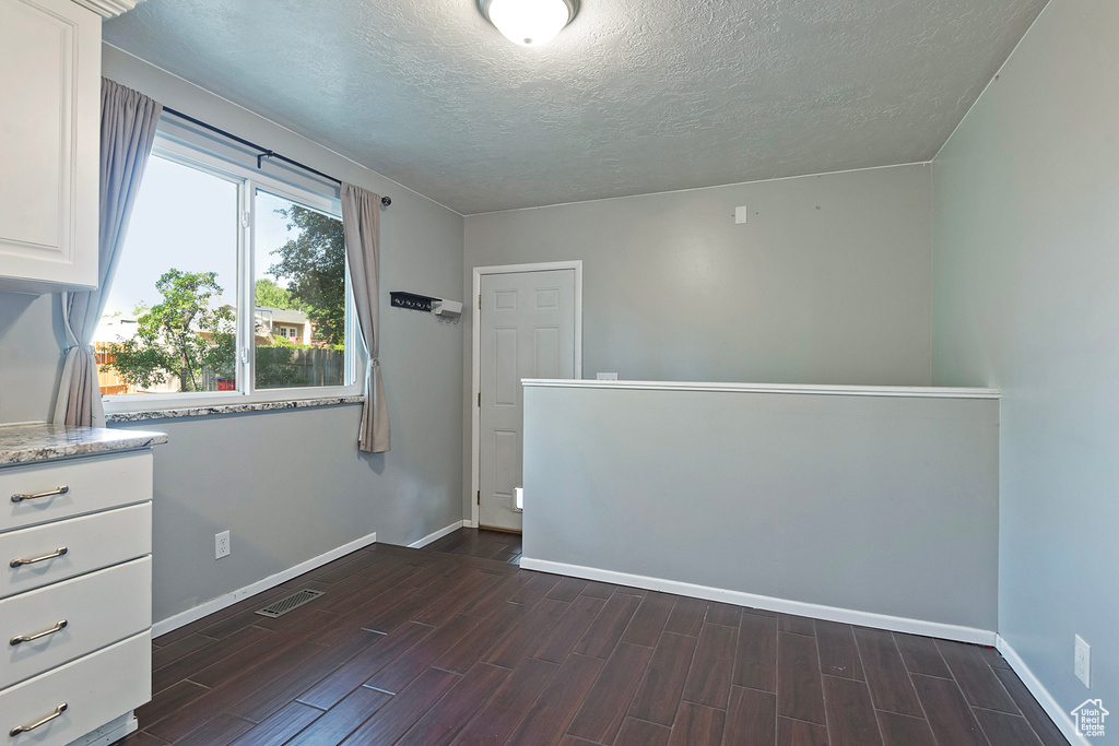 Interior space featuring a textured ceiling and dark hardwood / wood-style flooring