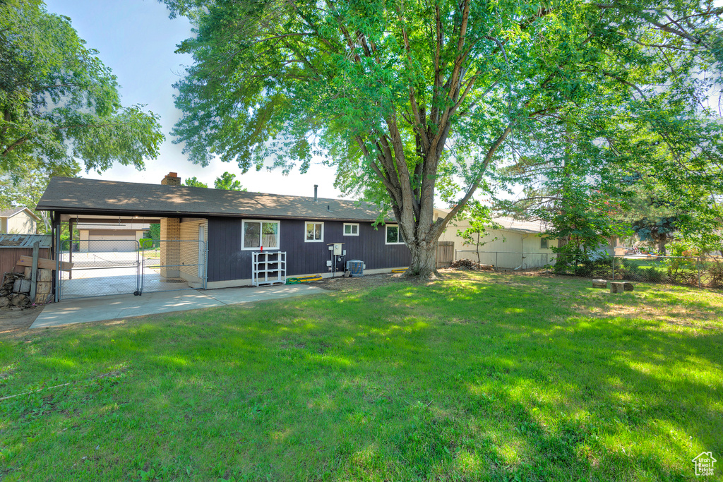 Back of property with a patio and a lawn