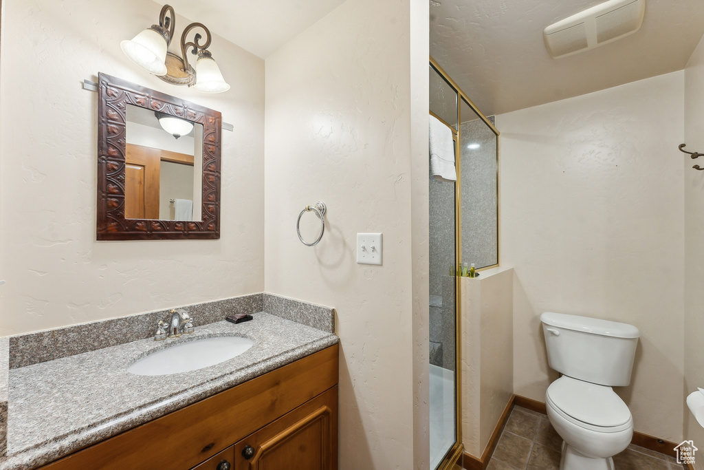 Bathroom with vanity, toilet, and tile patterned flooring