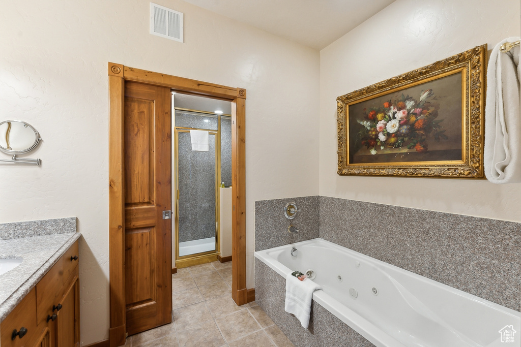 Bathroom with vanity, tile patterned flooring, and shower with separate bathtub