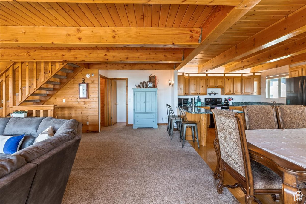 Carpeted dining room with beam ceiling and wood ceiling
