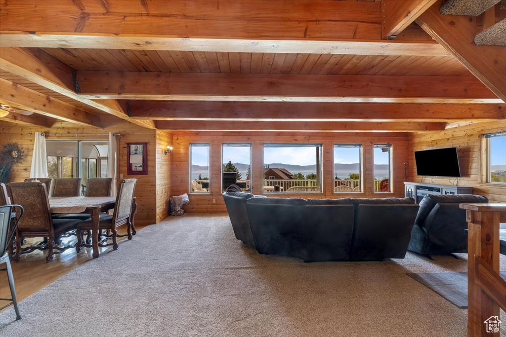 Living room featuring beamed ceiling, carpet flooring, and wooden ceiling