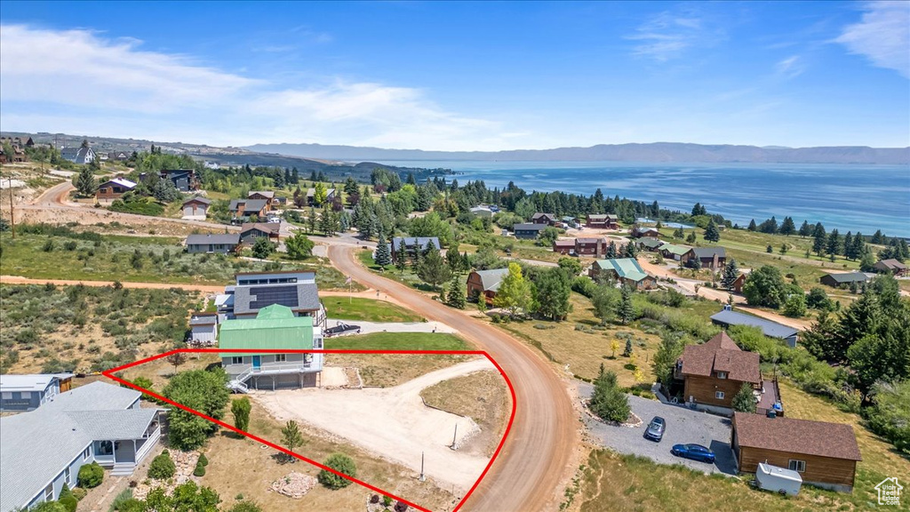 Birds eye view of property with a water and mountain view