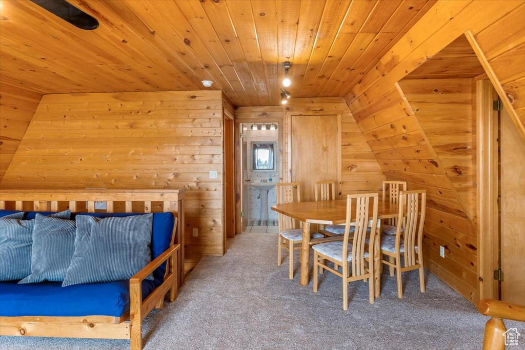 Carpeted bedroom with wood ceiling, wooden walls, and vaulted ceiling