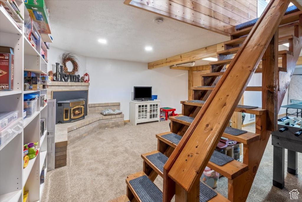 Basement with carpet flooring and a wood stove