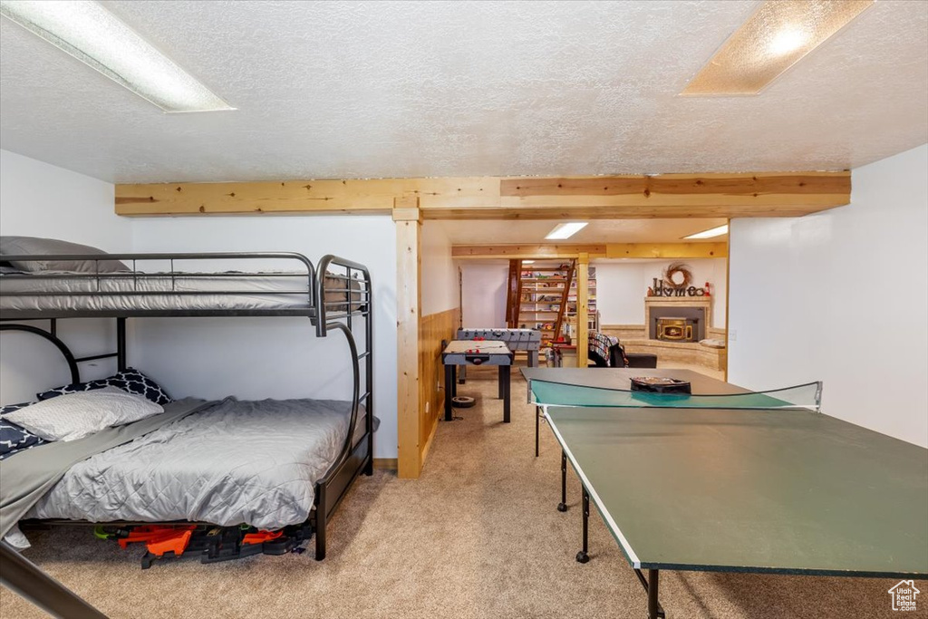 Carpeted bedroom with a textured ceiling and beam ceiling