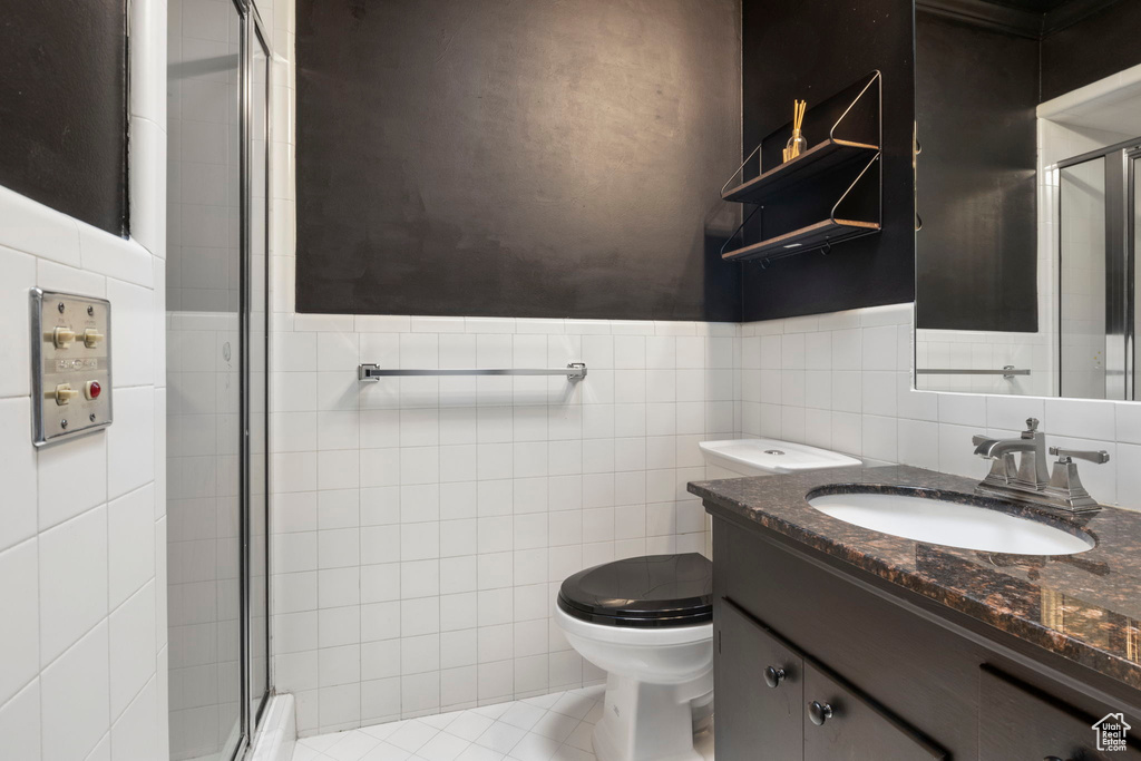 Bathroom featuring tile walls, tile patterned floors, and vanity