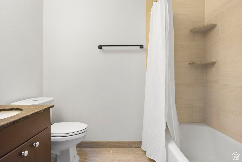 Full bathroom with vanity, tile patterned flooring, toilet, and shower / bath combination with curtain