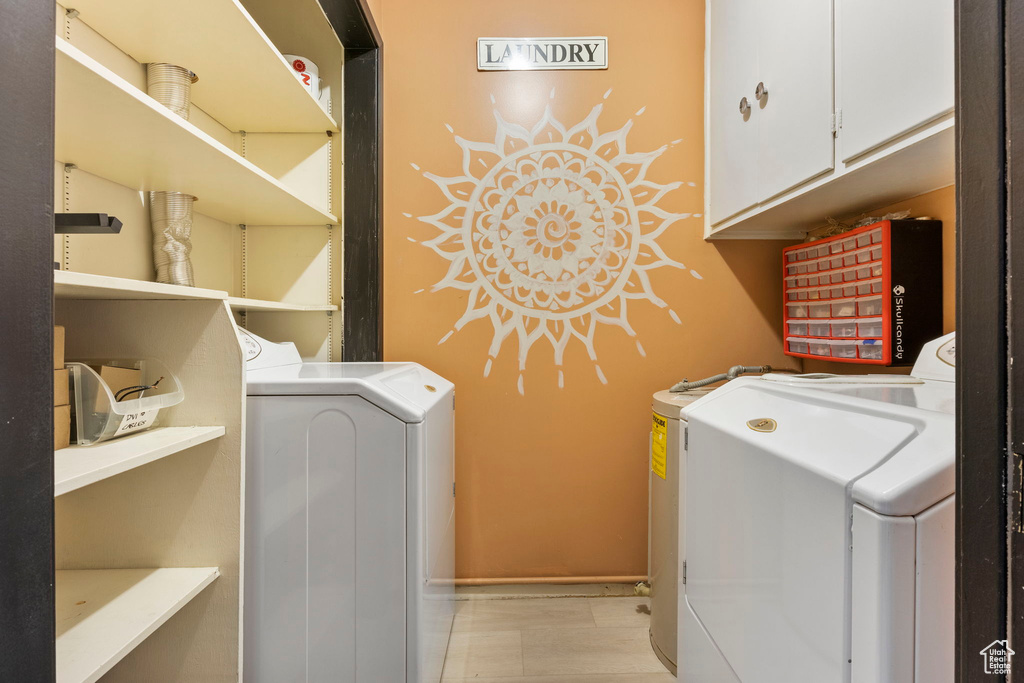 Washroom with cabinets and washer and clothes dryer