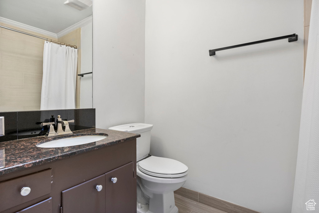 Bathroom with vanity, tile patterned flooring, toilet, and ornamental molding