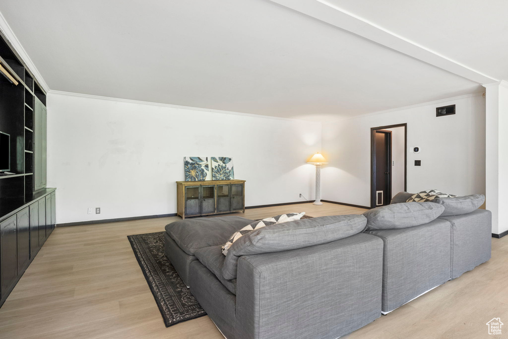 Living room with wood-type flooring and crown molding