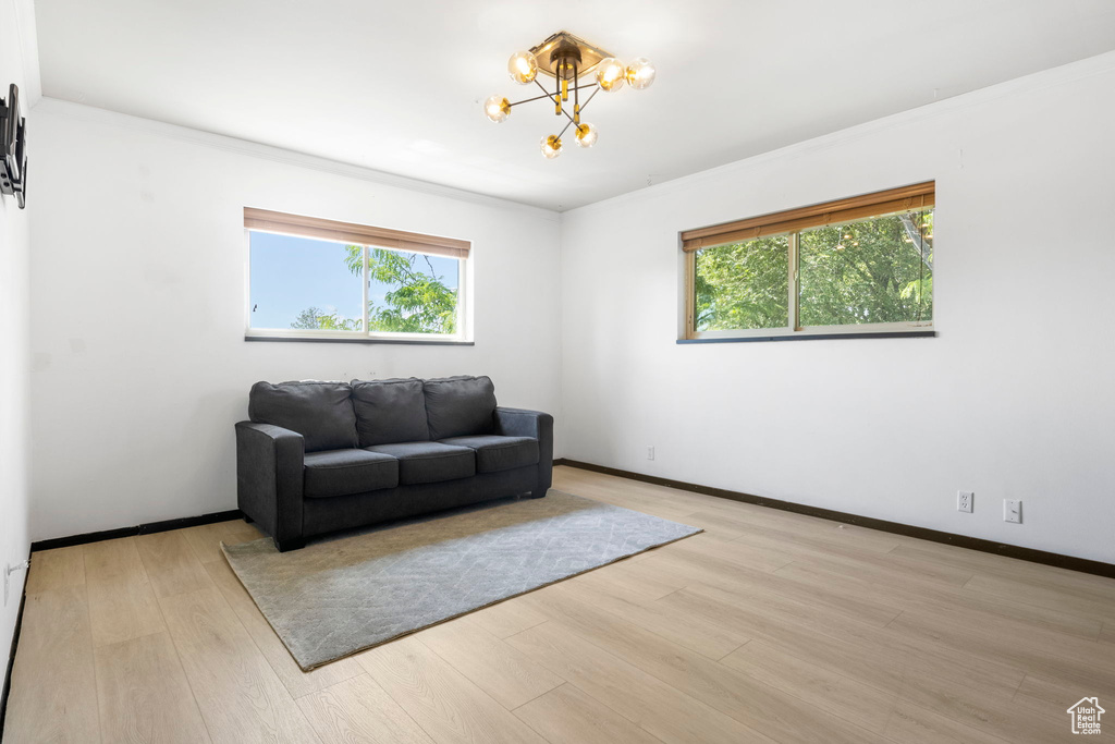 Living room featuring a healthy amount of sunlight, light hardwood / wood-style flooring, and a chandelier