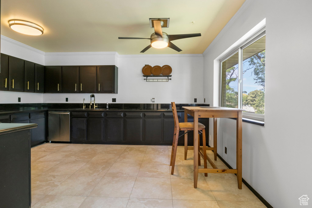 Kitchen with stainless steel dishwasher, ceiling fan, ornamental molding, sink, and light tile patterned floors