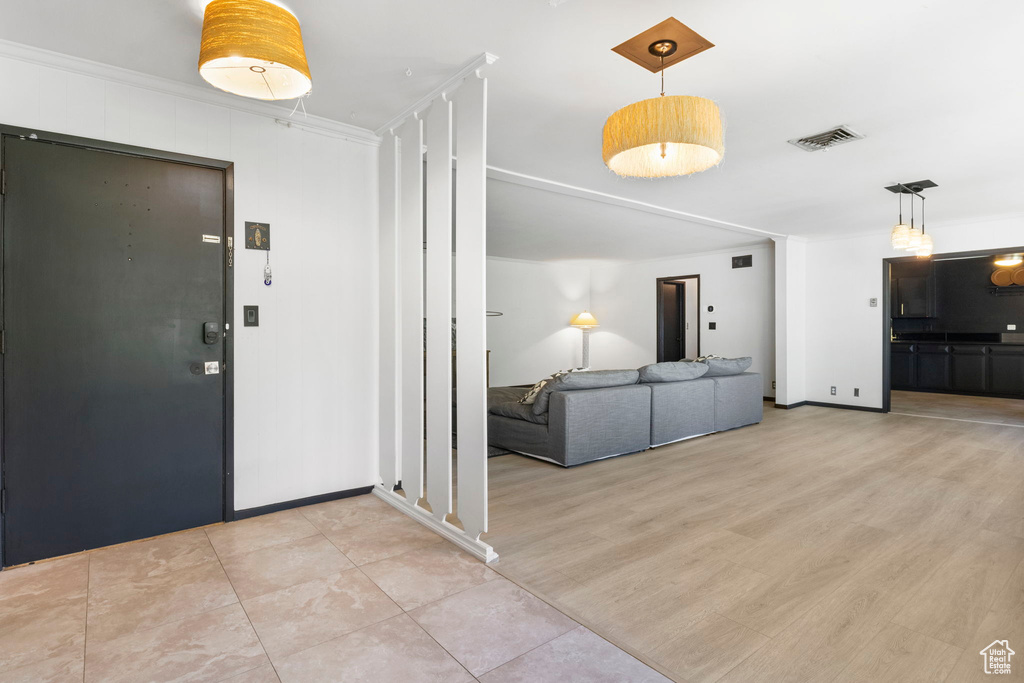 Entrance foyer featuring ornamental molding and light hardwood / wood-style floors