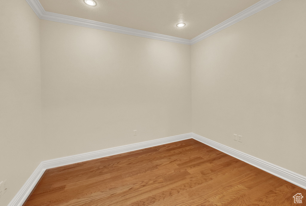 Empty room featuring crown molding and hardwood / wood-style floors