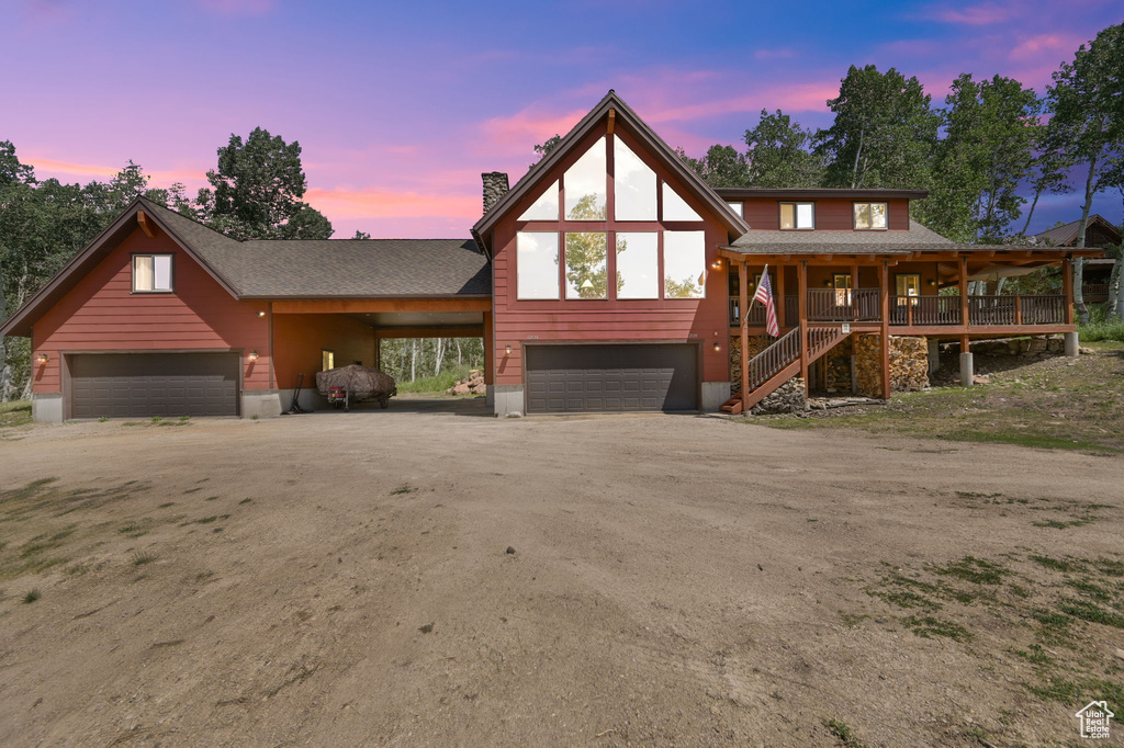 View of front of house with a garage, a porch, and a carport