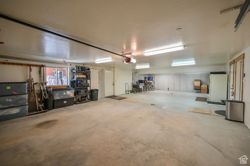 Garage with white fridge and a garage door opener