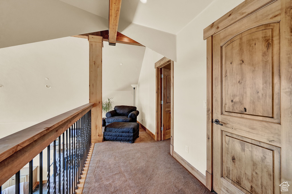 Hallway featuring vaulted ceiling with beams and carpet