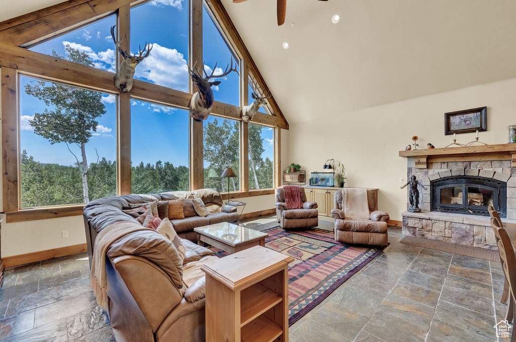 Living room with a fireplace, ceiling fan, plenty of natural light, and tile patterned flooring