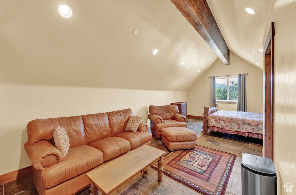 Bedroom with tile patterned floors and lofted ceiling with beams