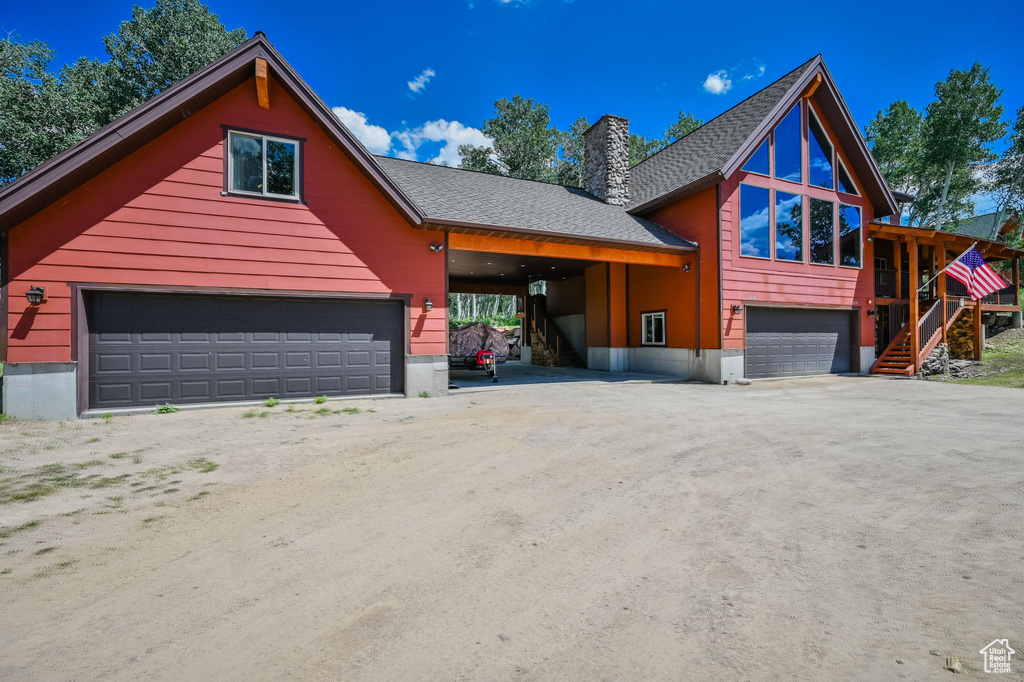 View of front of property featuring a carport and a garage