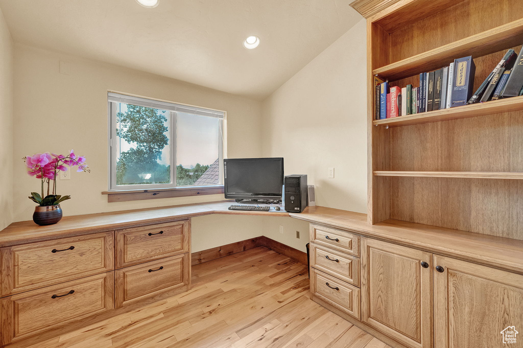 Office featuring light hardwood / wood-style flooring, built in desk, and vaulted ceiling