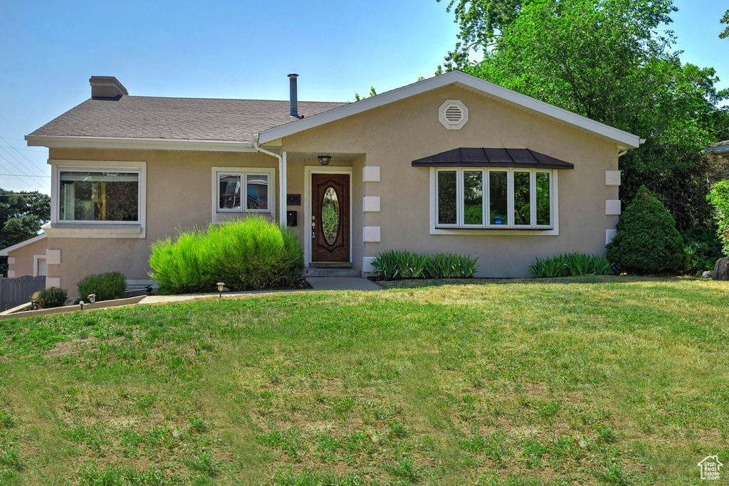 Ranch-style home featuring a front lawn