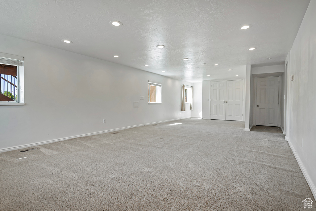 Spare room featuring light colored carpet and a wealth of natural light