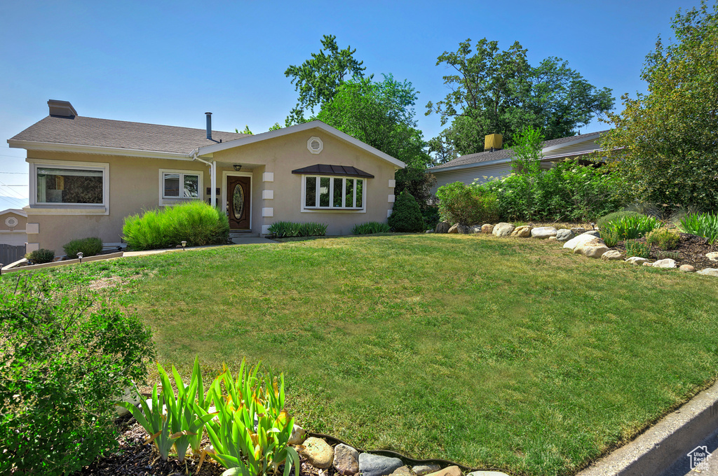 Ranch-style home featuring a front yard