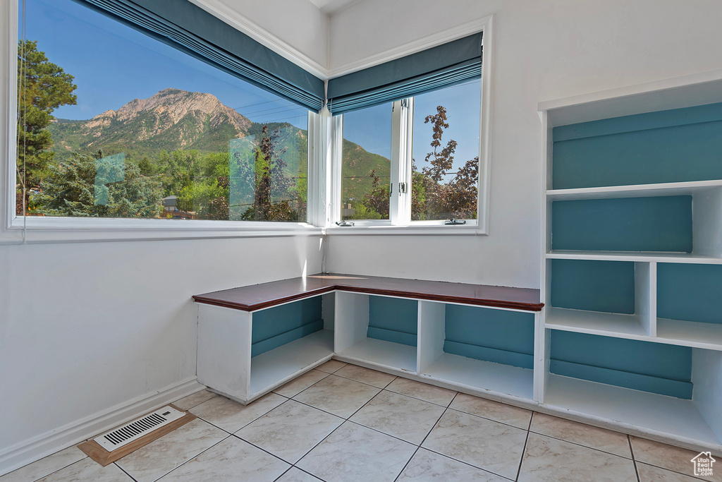 Unfurnished office with a mountain view and light tile patterned floors