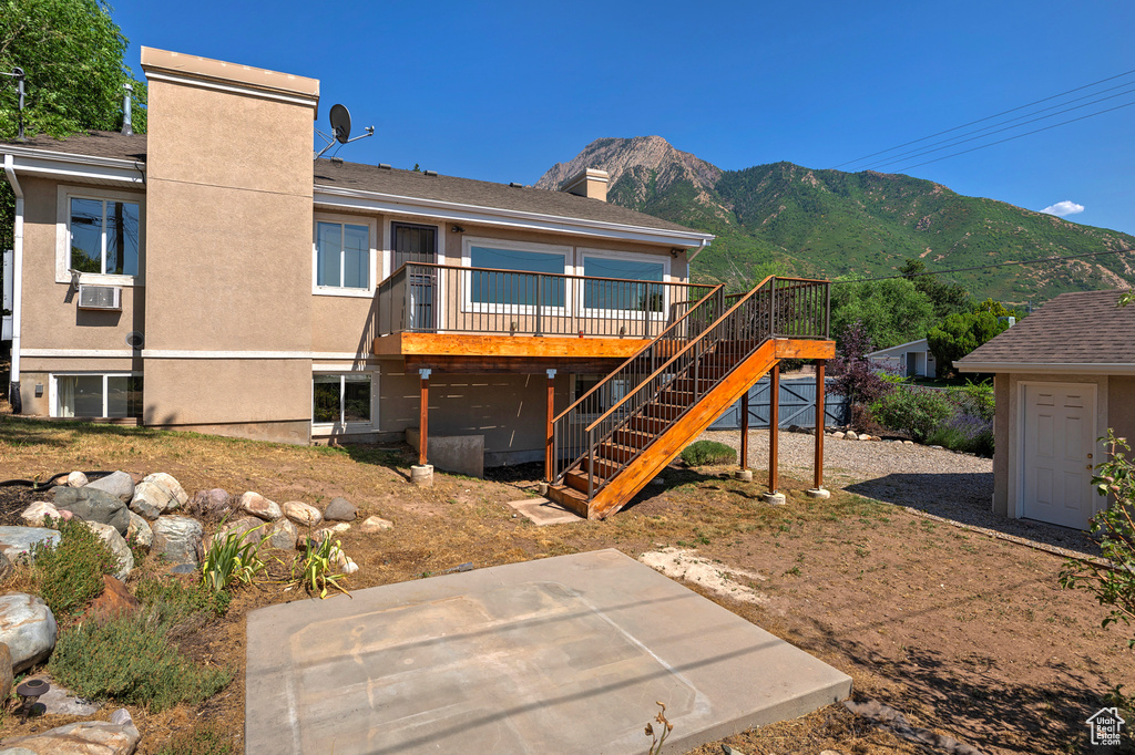 View of front of property featuring cooling unit and a deck with mountain view