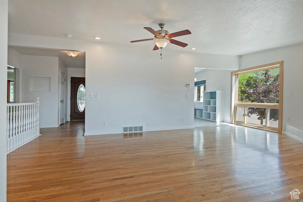 Unfurnished living room with wood-type flooring and plenty of natural light