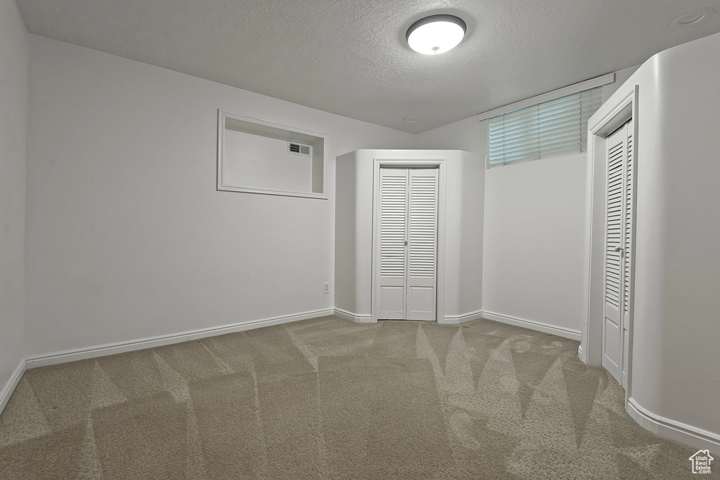 Unfurnished bedroom featuring carpet floors and a textured ceiling