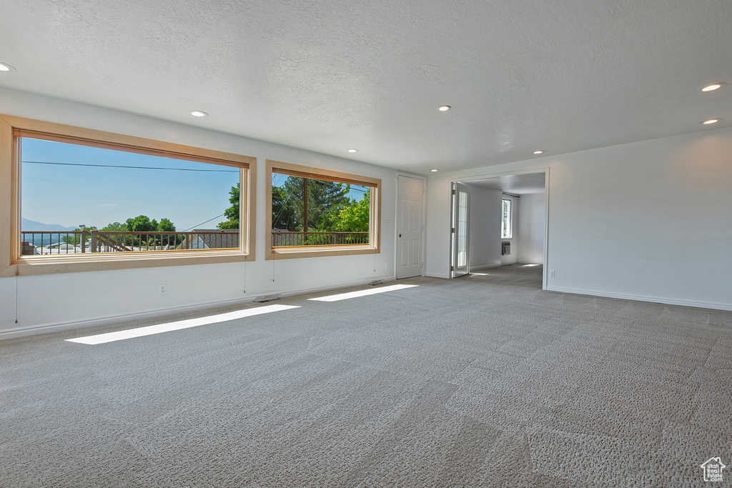 Carpeted empty room with a textured ceiling