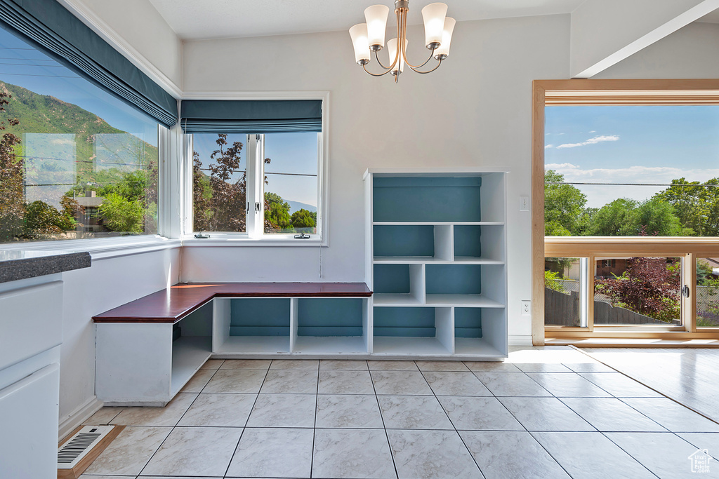 Unfurnished dining area featuring light tile patterned floors and a chandelier